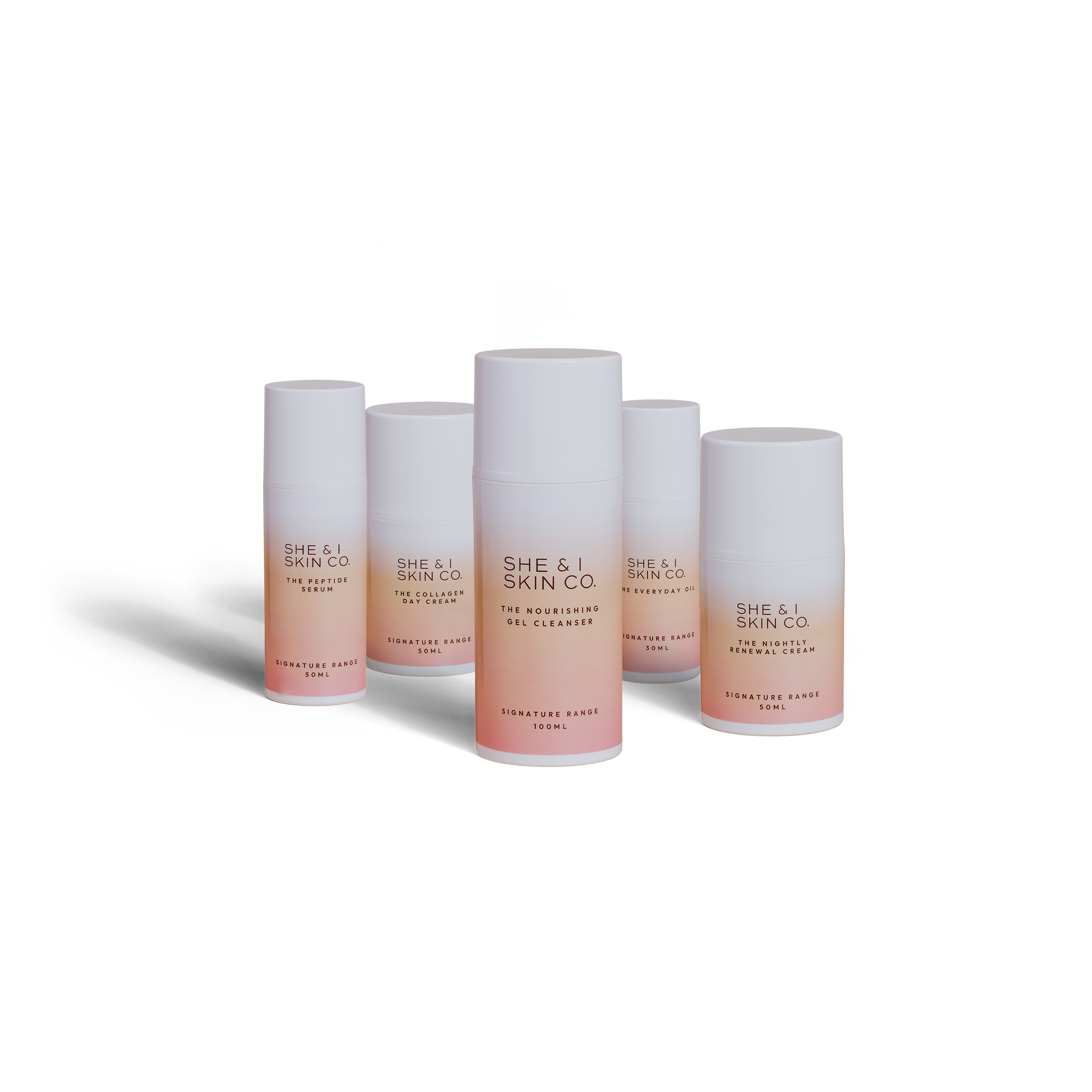 She & I Skin Co. skincare collection featuring cleansers, creams, and serums in sleek white-to-pink gradient packaging, perfect for a nourishing and luxurious skincare routine.