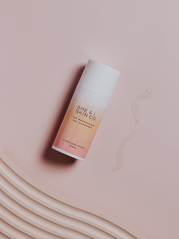 She & I Skin Co. "The Nourishing Gel Cleanser," 100ml, showcased with a clear gel smear on a soft pink background. The elegant textures emphasise its hydrating and refreshing qualities.